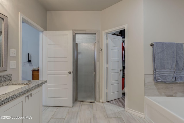 12010 N Crk 1500, Shallowater, TX 79363 - bathroom featuring vanity, a stall shower, a garden tub, baseboards, and a walk in closet