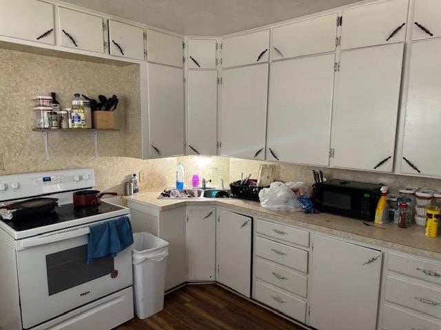 kitchen featuring dark hardwood / wood-style floors, white electric range, and white cabinets