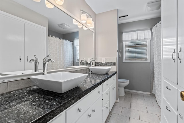 bathroom with vanity, tile patterned flooring, a wealth of natural light, and toilet