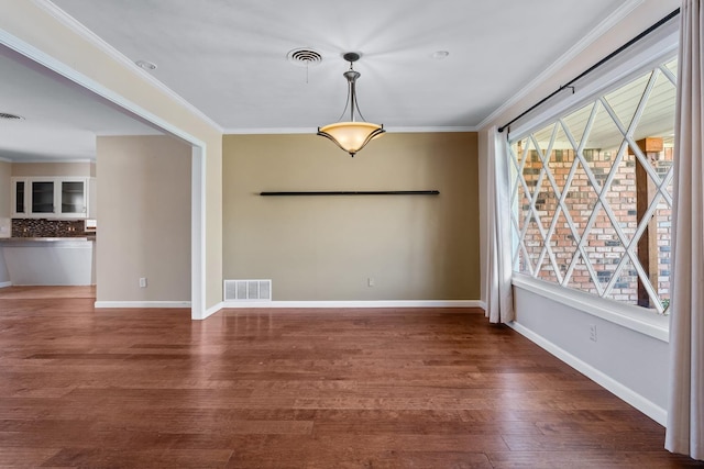 unfurnished dining area featuring ornamental molding and dark hardwood / wood-style floors