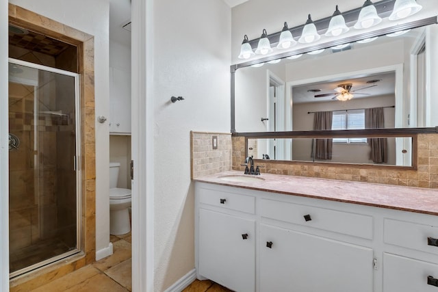 bathroom featuring a shower with shower door, backsplash, tile patterned flooring, vanity, and toilet