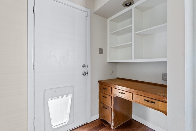 interior space with dark hardwood / wood-style flooring and built in desk