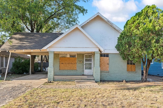 view of front of home with a front yard, a carport, and a porch