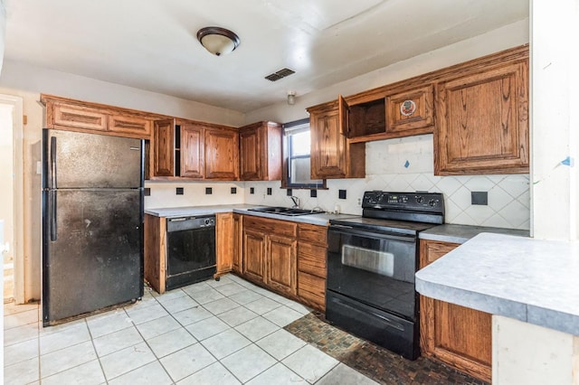 kitchen with light tile patterned floors, sink, decorative backsplash, and black appliances