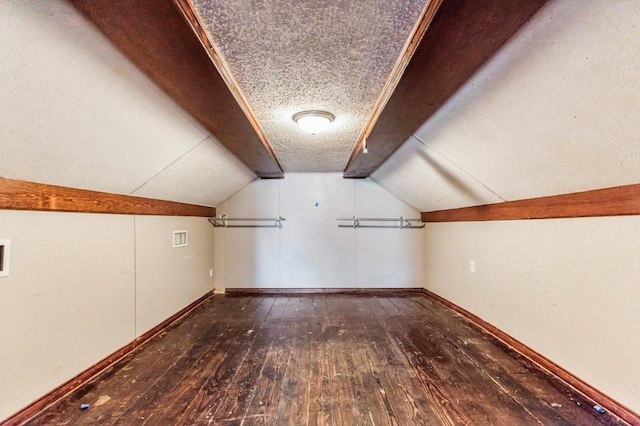 additional living space with wood-type flooring, a textured ceiling, and vaulted ceiling