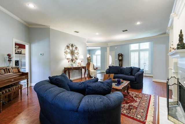 living room featuring hardwood / wood-style flooring, ornamental molding, plenty of natural light, and decorative columns