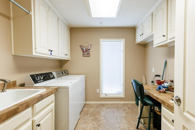 laundry area featuring cabinets, washer and dryer, and sink