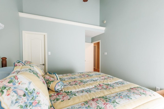 bedroom featuring ceiling fan and a high ceiling