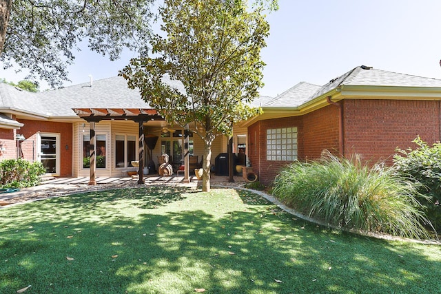 rear view of property featuring a pergola, a patio area, and a lawn