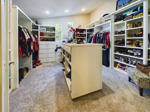 spacious closet with lofted ceiling and carpet flooring