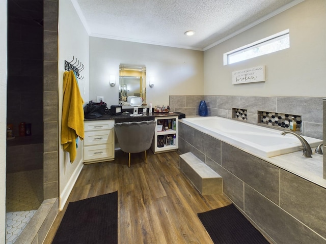 bathroom featuring wood-type flooring, separate shower and tub, a textured ceiling, ornamental molding, and vanity