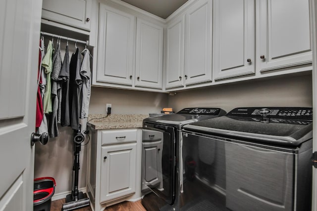 laundry area featuring cabinets, hardwood / wood-style flooring, and washer and dryer