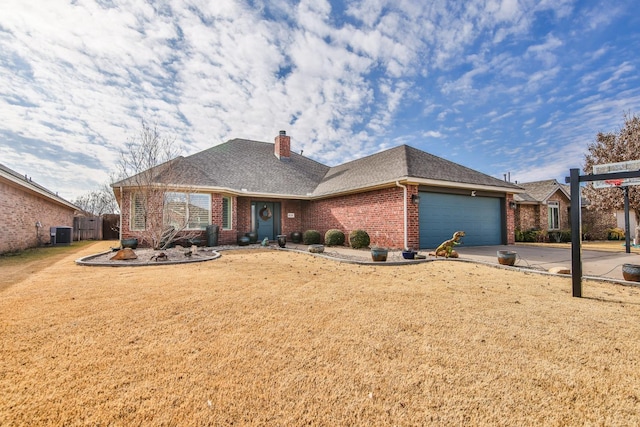 ranch-style home with a garage, central AC, and a front lawn