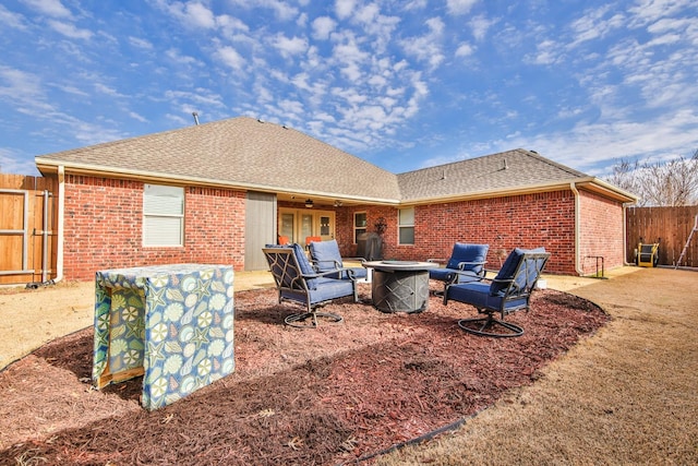 rear view of property featuring ceiling fan and an outdoor fire pit