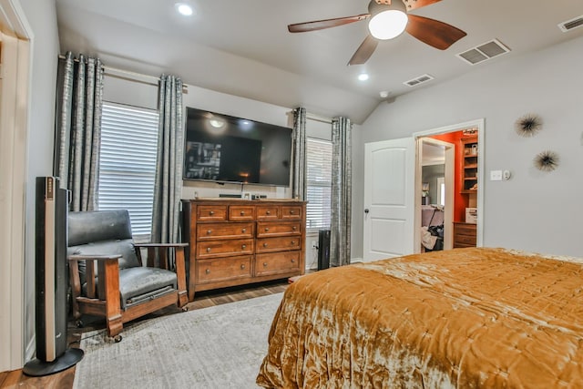 bedroom featuring lofted ceiling, hardwood / wood-style flooring, ceiling fan, a spacious closet, and a closet