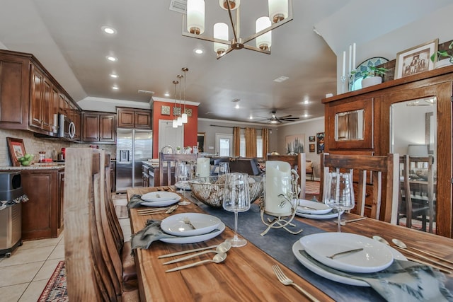 tiled dining room with ornamental molding and ceiling fan