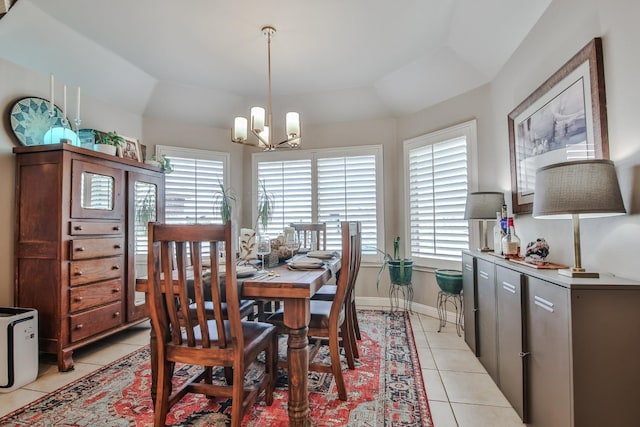 dining area with lofted ceiling, light tile patterned floors, a chandelier, and a tray ceiling