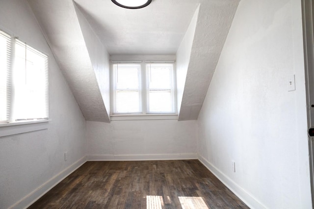 additional living space with lofted ceiling, dark hardwood / wood-style floors, and a healthy amount of sunlight