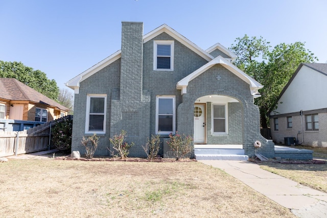 view of front of house with a front yard and central air condition unit