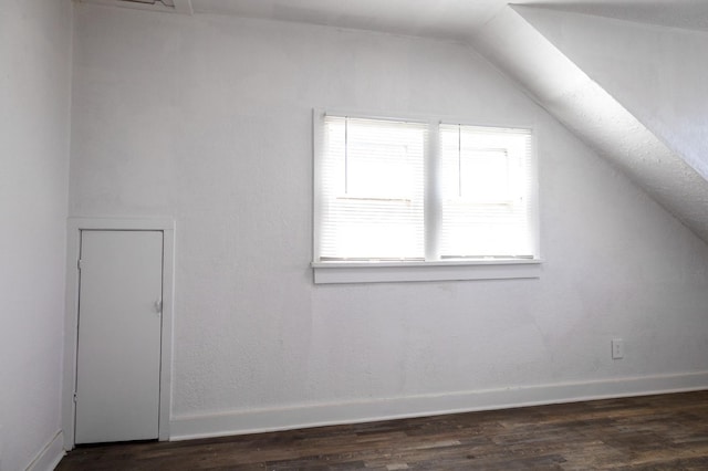 bonus room with dark hardwood / wood-style flooring and vaulted ceiling