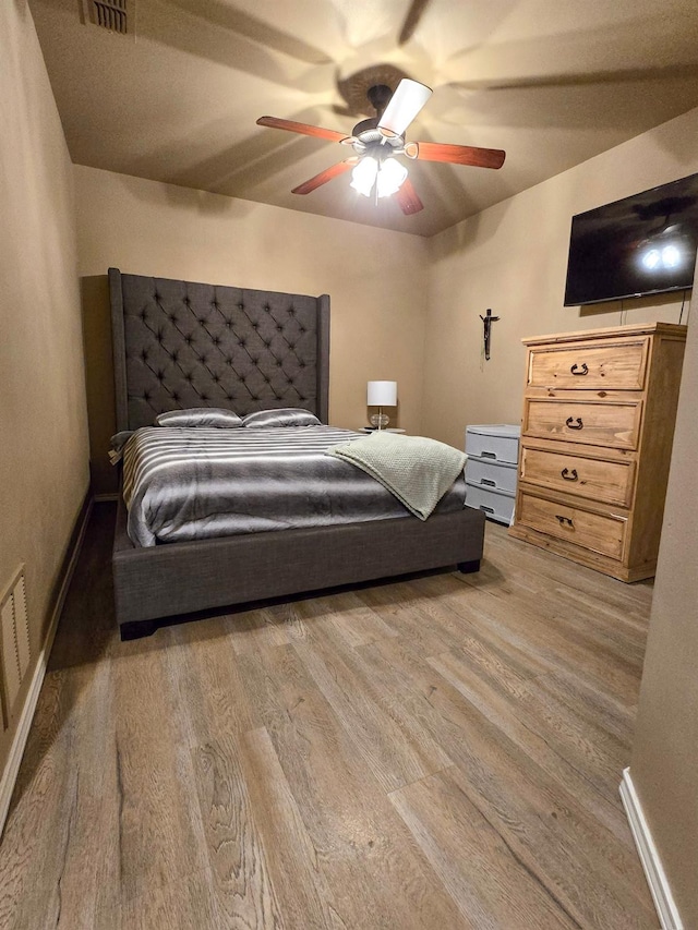 bedroom with ceiling fan and light hardwood / wood-style floors