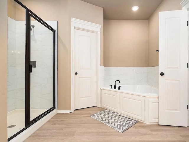 bathroom featuring hardwood / wood-style flooring and independent shower and bath