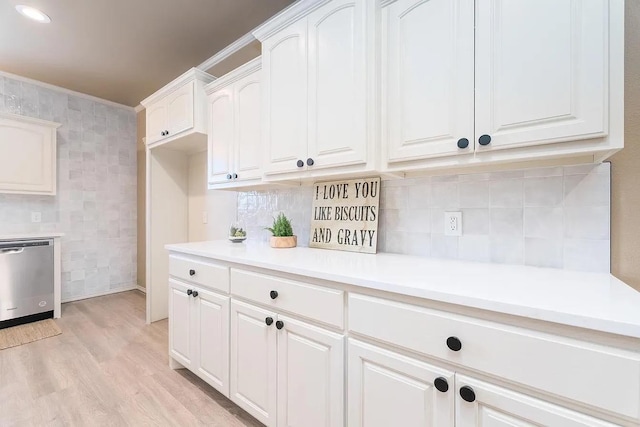 kitchen featuring decorative backsplash, stainless steel dishwasher, white cabinets, and light wood-type flooring