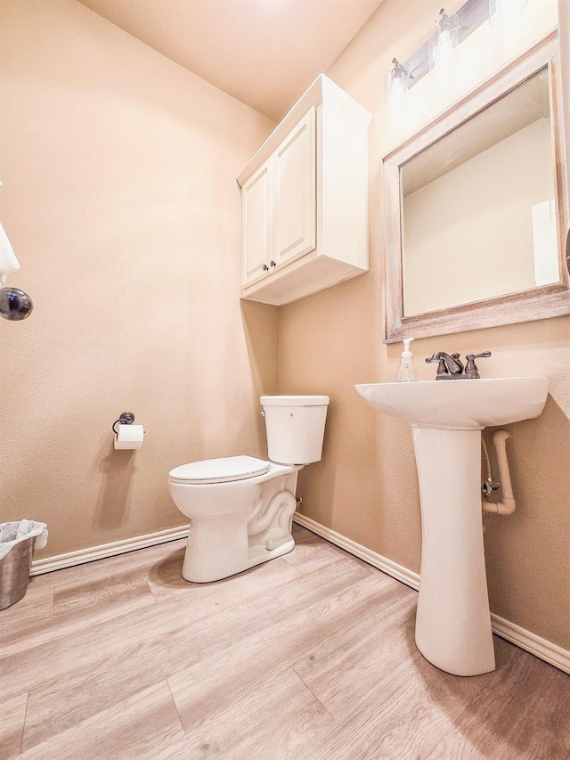 bathroom featuring hardwood / wood-style floors and toilet