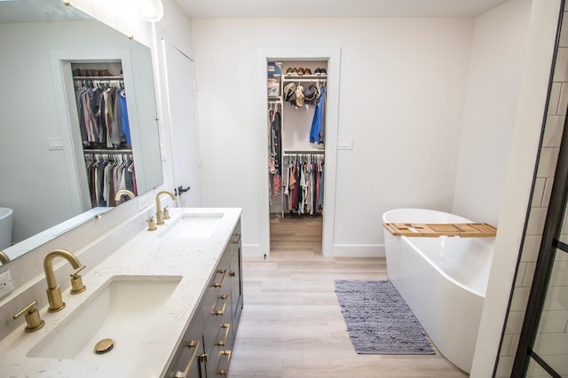 bathroom featuring vanity, wood-type flooring, and a tub