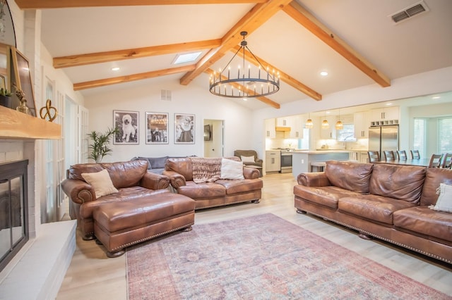 living room with high vaulted ceiling, a skylight, beamed ceiling, a notable chandelier, and light wood-type flooring