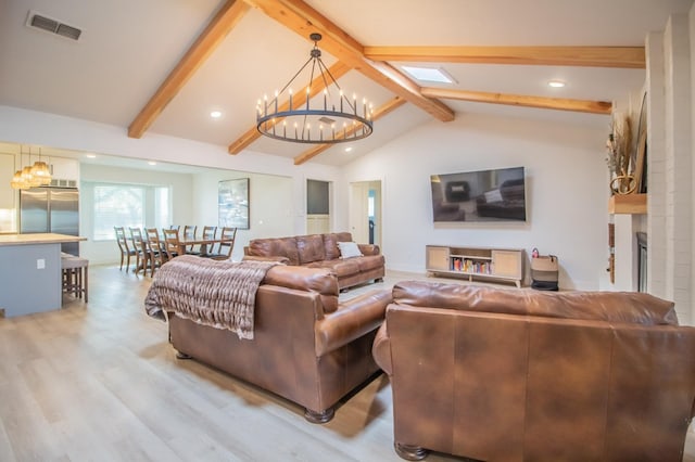 living room with lofted ceiling with skylight, wood-type flooring, and a notable chandelier