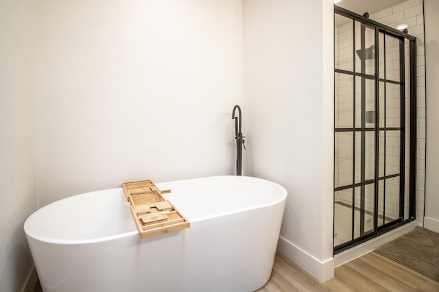 bathroom featuring hardwood / wood-style flooring and separate shower and tub