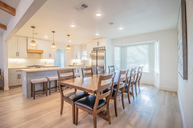 dining space featuring sink, a wealth of natural light, and light hardwood / wood-style flooring