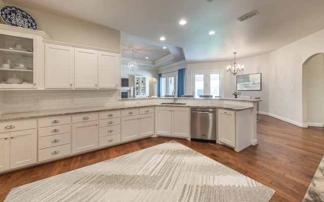 4003 124th St, Lubbock, TX 79423 - kitchen featuring dishwasher, arched walkways, a chandelier, a peninsula, and decorative backsplash