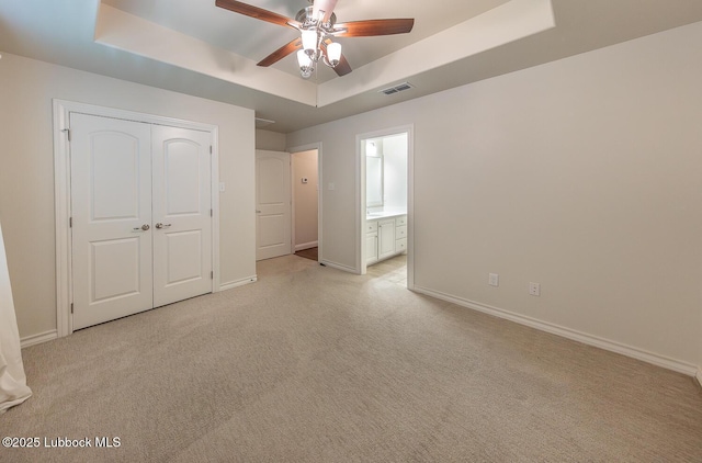4003 124th St, Lubbock, TX 79423 - unfurnished bedroom featuring a raised ceiling, light colored carpet, a closet, and connected bathroom