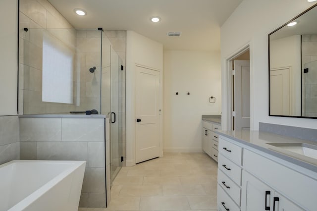 bathroom with tile patterned flooring, plus walk in shower, and vanity