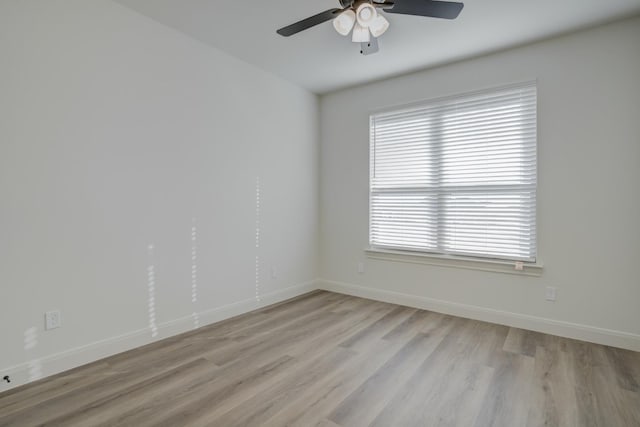 empty room with ceiling fan, plenty of natural light, and light hardwood / wood-style floors