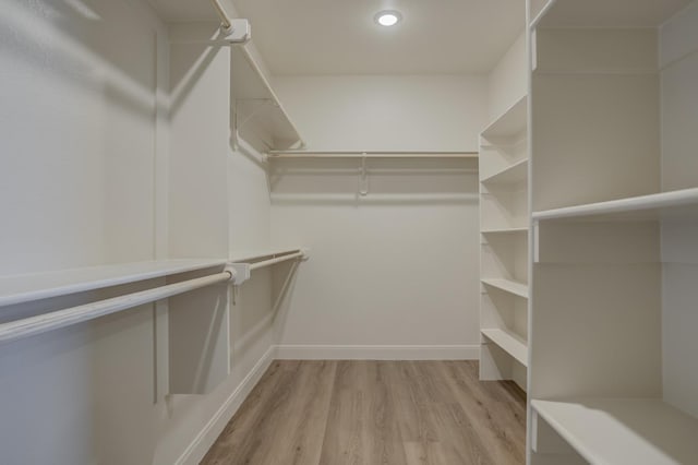 walk in closet with light hardwood / wood-style floors