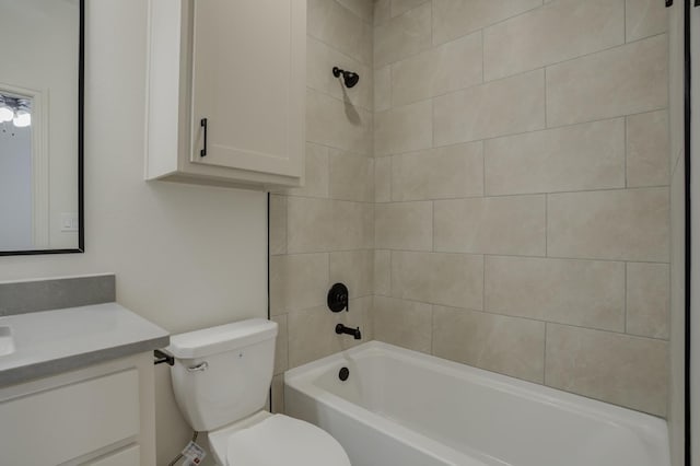 full bathroom with tiled shower / bath, vanity, and toilet