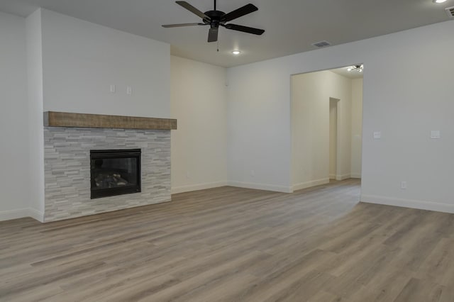 unfurnished living room featuring a fireplace, ceiling fan, and light wood-type flooring