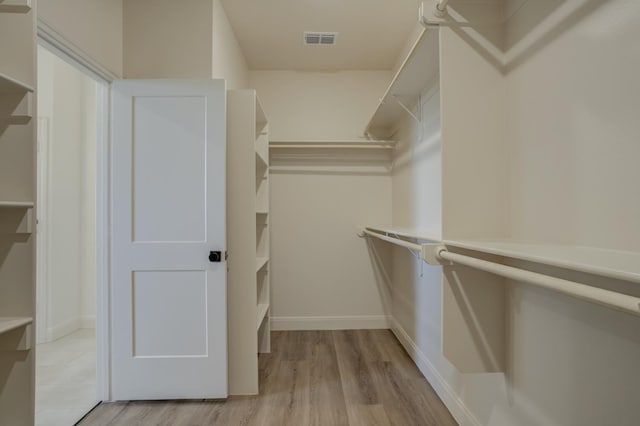 spacious closet with light hardwood / wood-style flooring