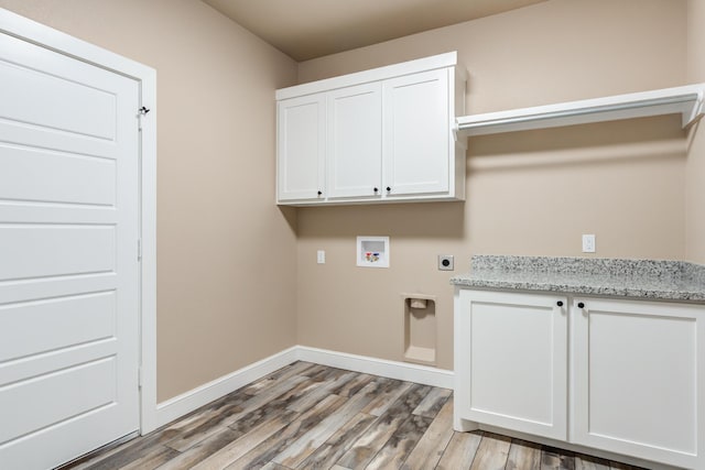 laundry area with cabinet space, baseboards, light wood-style flooring, hookup for a washing machine, and electric dryer hookup