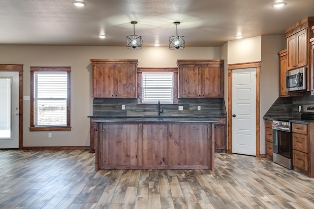 kitchen with stainless steel appliances, tasteful backsplash, and pendant lighting