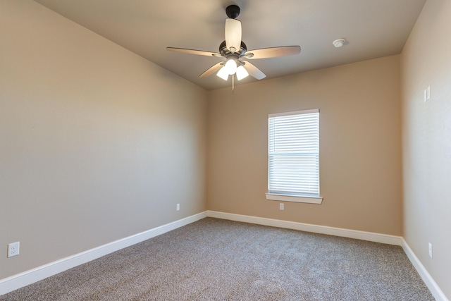 carpeted spare room featuring a ceiling fan and baseboards