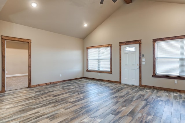 foyer entrance with baseboards, high vaulted ceiling, and wood finished floors