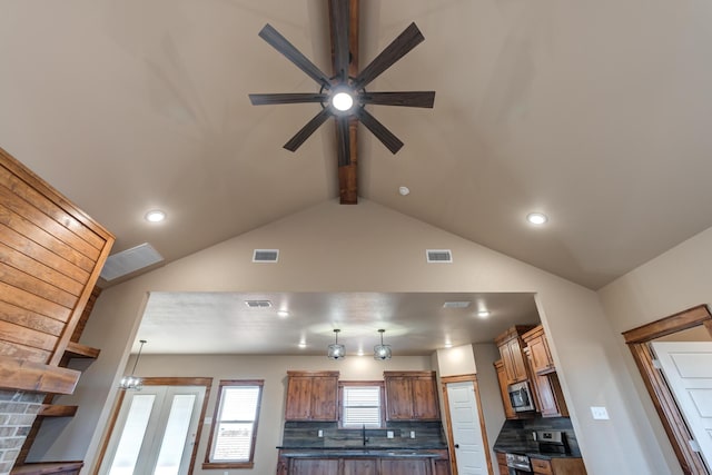 room details featuring stainless steel appliances, beam ceiling, dark countertops, and visible vents