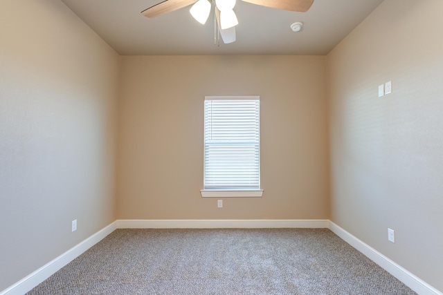 carpeted spare room with ceiling fan and baseboards