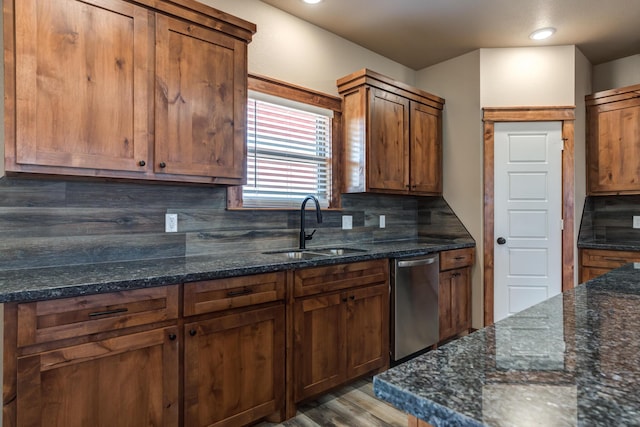 kitchen featuring decorative backsplash, dark stone counters, a sink, and dishwasher