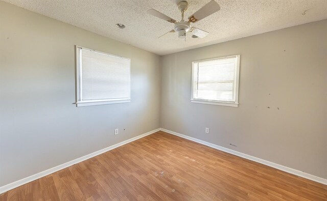 unfurnished room featuring ceiling fan, light hardwood / wood-style floors, and a textured ceiling