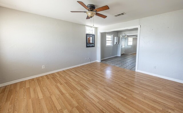 empty room with ceiling fan and light hardwood / wood-style flooring